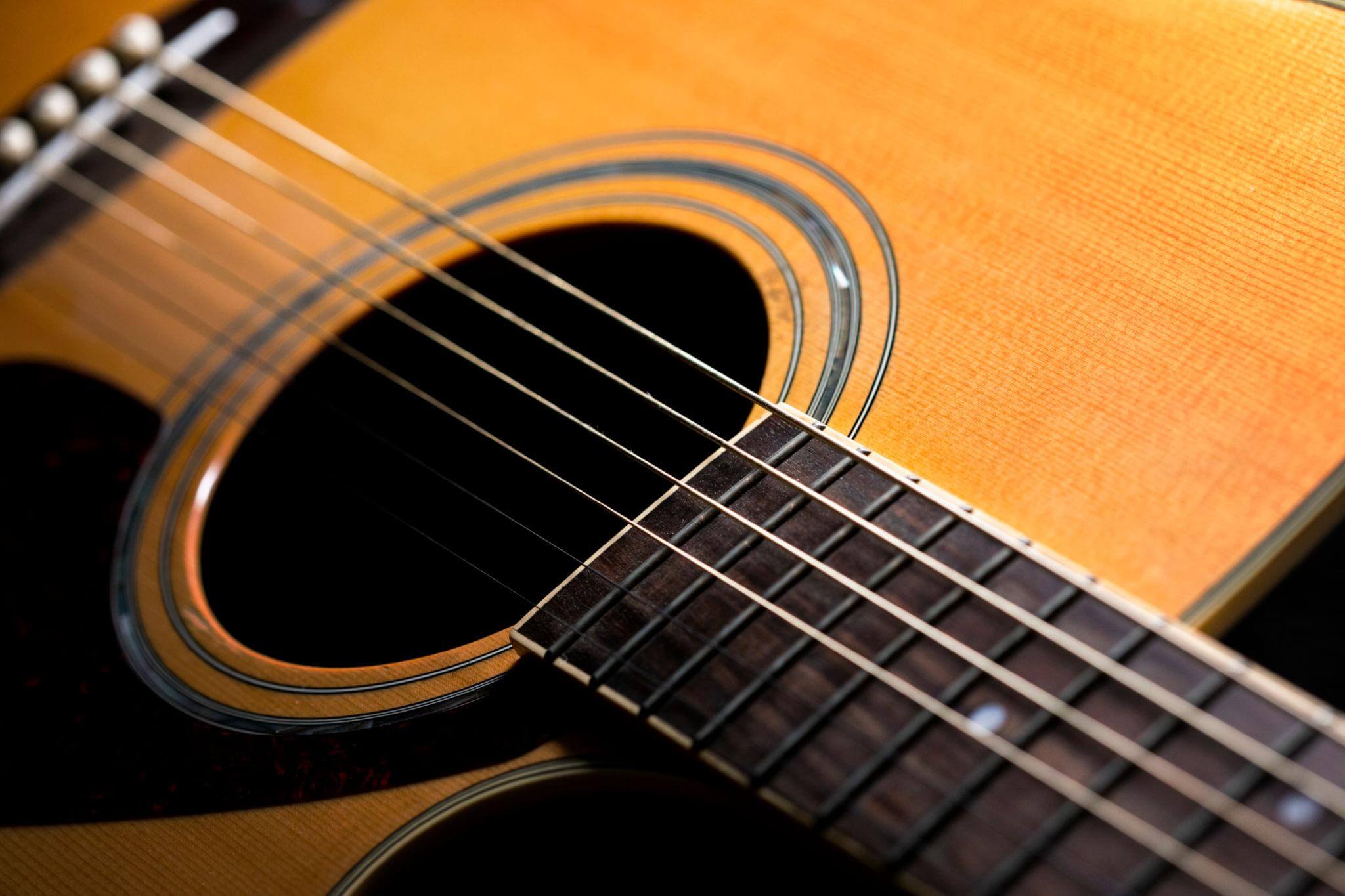 Close-up of an acoustic guitar soundhole, strings and fretboard